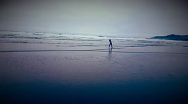 Totally cool Boy runs along the beach in front of high whitecap waves
