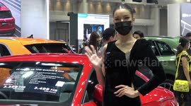 Thai models pose in face masks as motor show opens with with luxury cars from Rolls Royce and Aston Martin