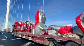 Motorist spots truck carrying several Japanese superhero models along bridge in China