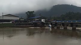 Bridge collapses after being battered by raging river during floods in southern Thailand