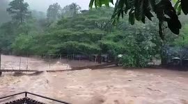 Raging river submerges bridge after heavy rain causes floods in southern Thailand