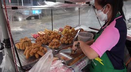 Thai street food vendors serve customers despite rain storm in Bangkok