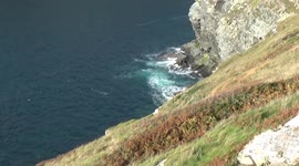 Tintagel Bridge on a Sunny Day, the sea is clear and blue and its very high water and the Bridge is sparkleing