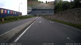 Impatient driver jumps queue of traffic by using a left turn only lane then cuts in front narrowly missing traffic island while another driver browses their phone in the queue
