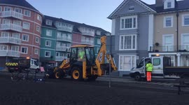 JCB clears the aftermath of Storm Barra on Aberystwyth seafront.