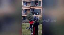 Brave delivery man climbs building to rescue family trapped in burning second-floor flat in China