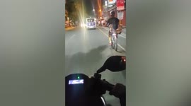 Two cute dogs enjoy night ride on bike in the Philippines