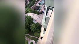 Man lowers crab from apartment to retrieve clothes that fell off balcony in China