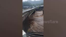 Flood nearly submerges bridge as river level swells during super typhoon Rai in the Philippines