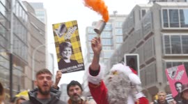 Santa waving red smoke flare at COVID march in London