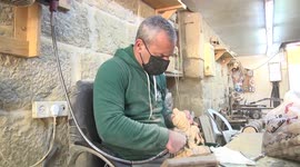 Palestinian artisan carves Christmas ornaments from olive wood in Bethlehem