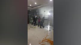 Office staff battle against super typhoon Rai winds shaking glass entrance of building in the Philippines