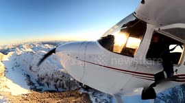 Flying a Cessna 172 over the snow covered mountains during sunset in Squamish, British Columbia, Canada.