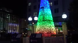 Festive Charing Cross station with rainbow Christmas tree and Merry Christmas rickshaw
