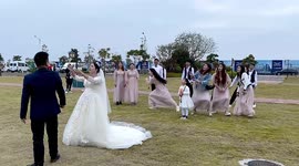 Bridesmaids scatter in hilarious fashion during bride's bouquet toss at wedding in China