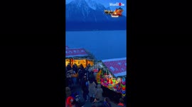 Kids cheer as Santa Claus rides sleigh over Christmas market in Switzerland