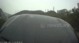 Motorist forced to brake as car hood pops open on road in southern China