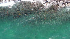 Aerial view approaching ocean waves, turquoise blue water and rocks at Puerto Peñasco bay in Sonora, Mexico. landscape of beach, sea, hotel and real estate industry. Gulf of California desert. Sea of Cortez, Bermejo Sea