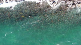Aerial view approaching ocean waves, turquoise blue water and rocks at Puerto Peñasco bay in Sonora, Mexico. landscape of beach, sea, hotel and real estate industry. Gulf of California desert. Sea of Cortez, Bermejo Sea