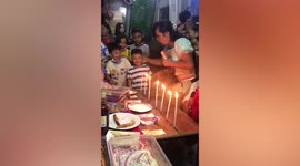 Family play candle blowing game during Christmas festivities in the Philippines