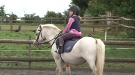 Young girl manages to remain seated on spooked horse during UK riding lesson