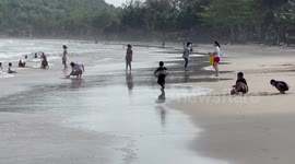 Families enjoy beach during windy weather in southern Thailand