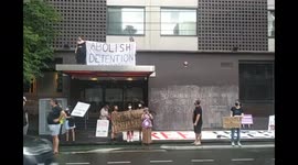 Protest ongoing outside immigration prison Park Hotel, Carlton, where Novak Djokovic is temporarily detained. Unlike the refugees in indefinite detention held there.  Refugees supporters locked on in a cage at the front. Refugees looking down from locked