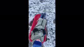 Snow covers Scotland: 3-year-old sleds down hill near Glasgow