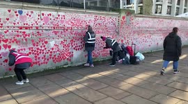 Volunteers repaint hearts on the National COVID Memorial Wall in London