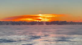 Lone bird flies over the rising steam of a frigid Lake Michigan in January 2022