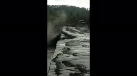 Mother and Motorcyclist Desperately Crossing a Bridge in Lava Flooded Mount Semeru Lumajang, East Java, Indonesia