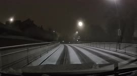Dashcam view of a near miss after car slides on a snow covered road.