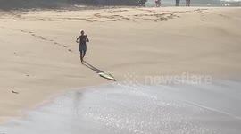Broken surfboard after wipeout, surfer collects pieces of his board at Waimea bay hawaii Oahu
