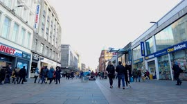 Boy stunt cycling through pedestrians on a busy shopping street.