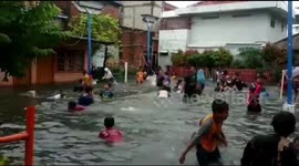 Kids take advantage of Jakarta floods by swimming in submerged streets