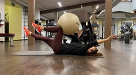Fitness trainer from Moscow, Russia shows a dead bug with fitball exercise