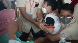 Indonesian boy screams in fear of Covid-19 vaccination as officials restrain the panicked lad