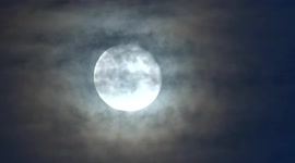 Beautiful Wolf moon shining through clouds over central London