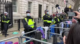 Downing St barriers covered in scrubs as anti-vaccine protesters throw NHS uniforms at police