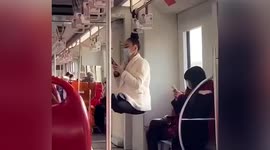 Russian woman ties hair on handrail to swing on train in China