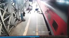 Railway police drag man to safety who slips while boarding moving train in western India