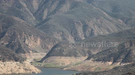 Fire helicopters approach through rugged terrain (Castaic Warm Fire) V18937
