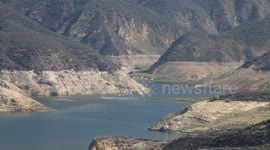 Fire helicopter hovers over water while loading tank (Castaic Warm Fire) V18938