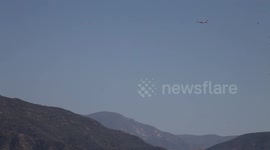 A fire-fighting DC-10 flies low and slow over Castaic Lake (warm fire) V18945