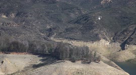 Fire helicopter fly-by over rugged lake terrain (Castaic Warm Fire) V18949