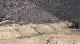 Fire helicopter panning fly-by over rugged lake terrain (Castaic Warm Fire) V18949