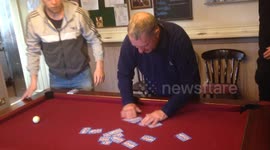 Magician performs card trick on pool table
