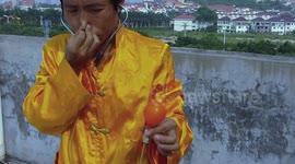 Man blow a balloon using his ears