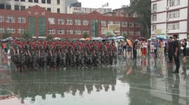 中学生军训雨中会操表演 校长不打伞“陪淋”