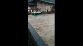 Floods carry bus into river where it sinks